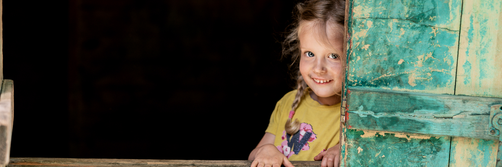 Kindergartenfotografie - ein Kind blickt aus einem Fenster